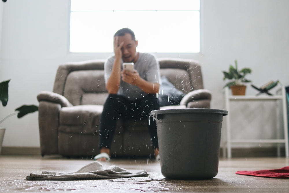 Stressed Man Calling Water Damage Repair Service